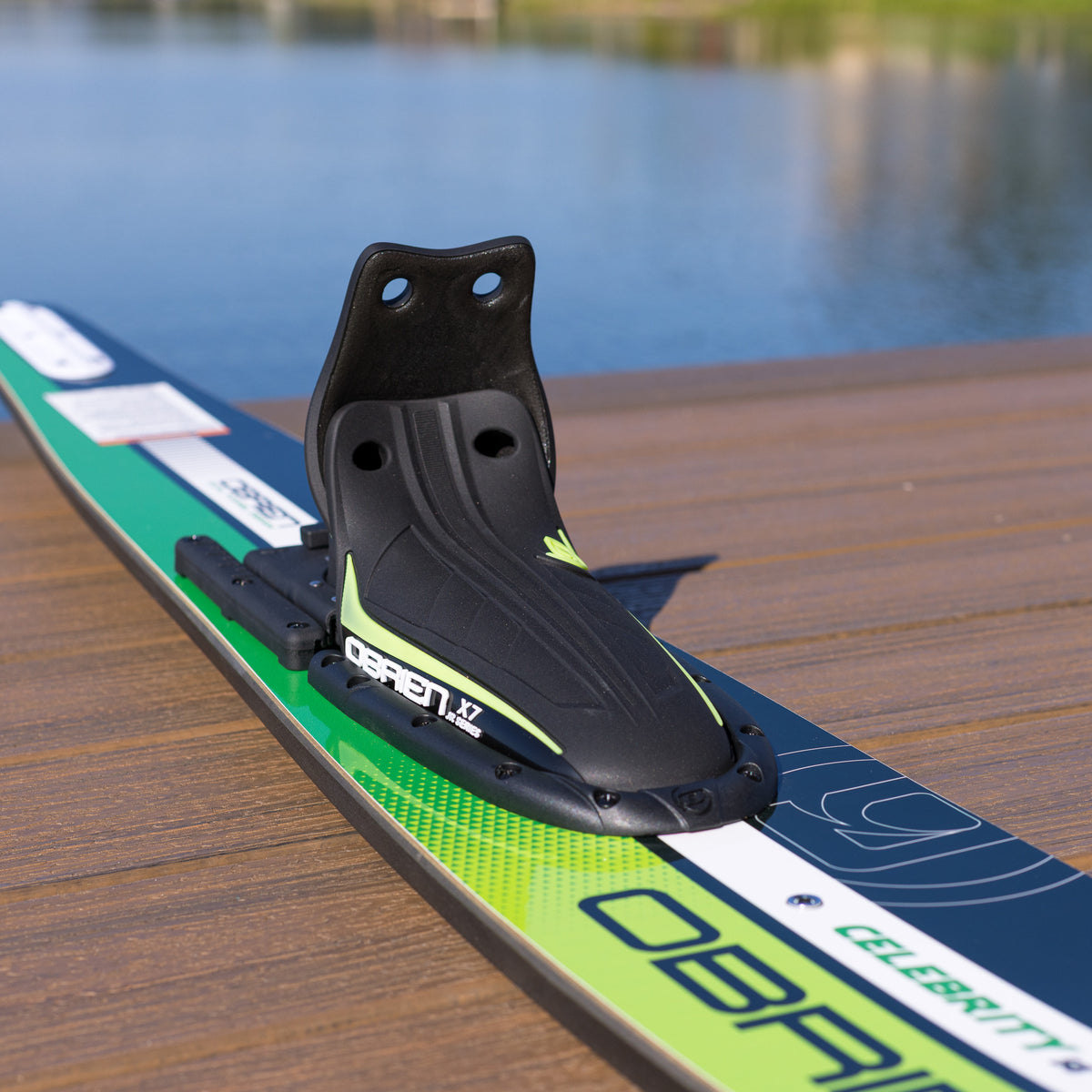 Close-up of a water ski boot binding on a water ski with a lake in the background