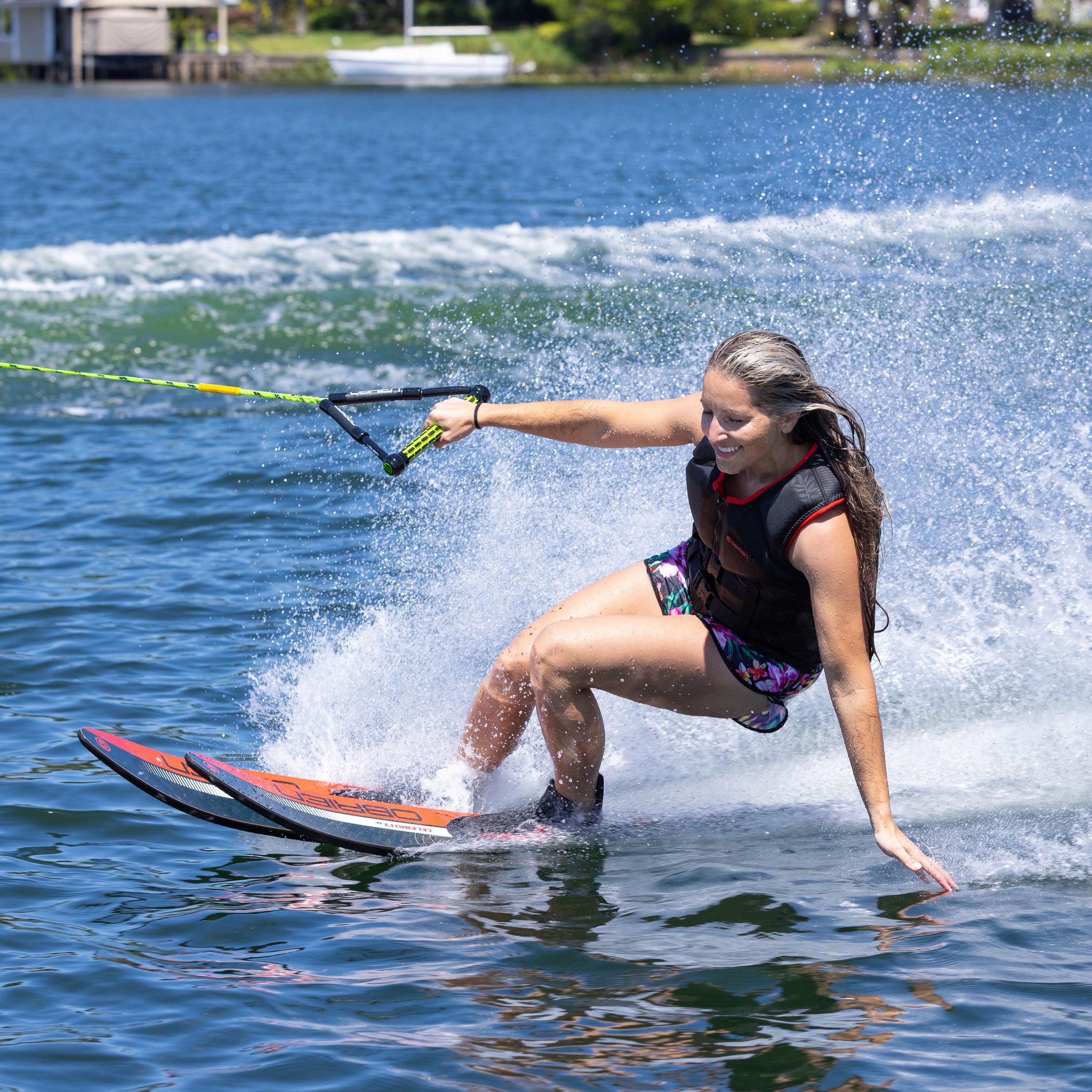 Person water skiing on a lake with building in background