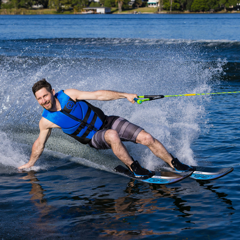 Man water skiing on a lake with buildings in the background