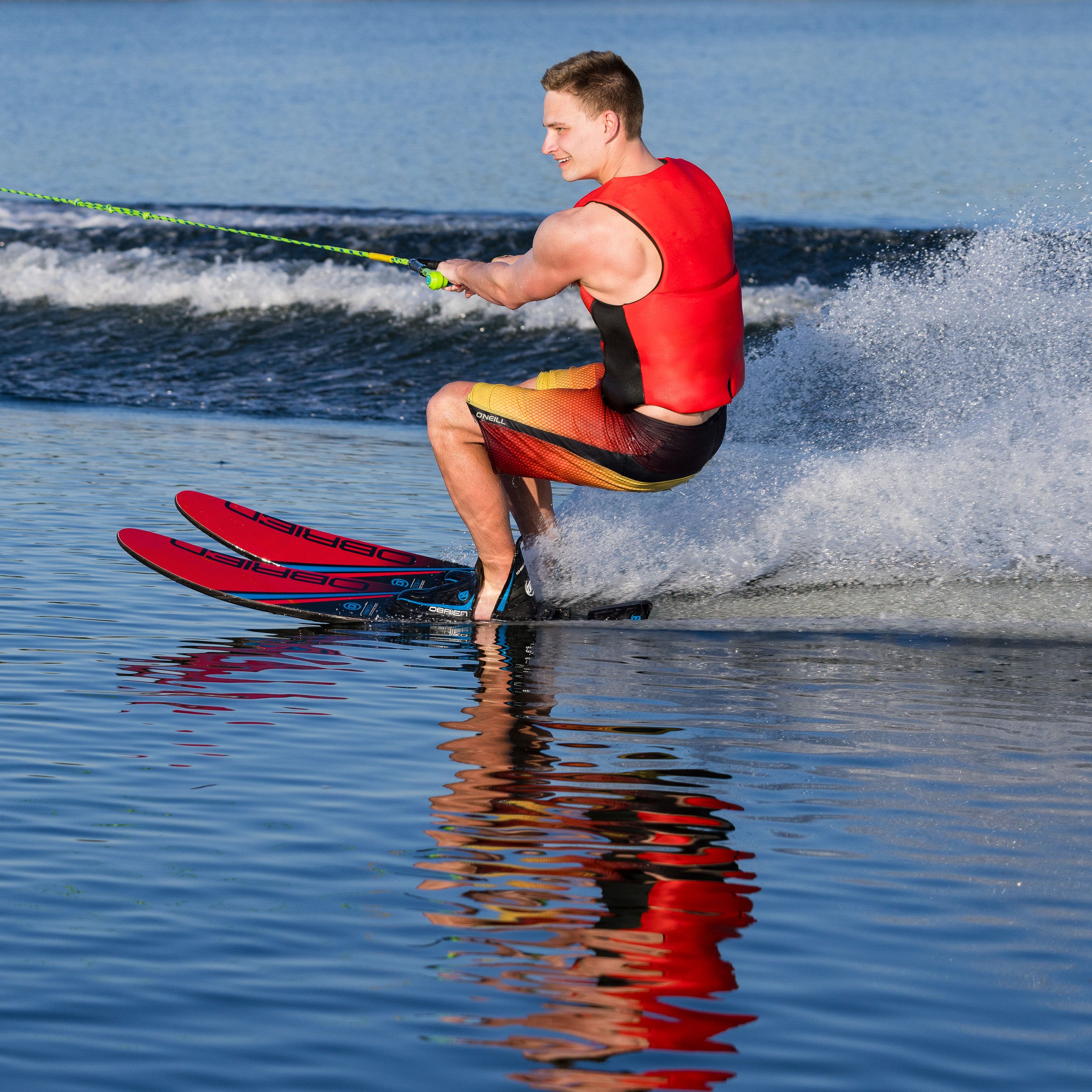 Man in red life jacket water skiing on red O'Brien Water skis