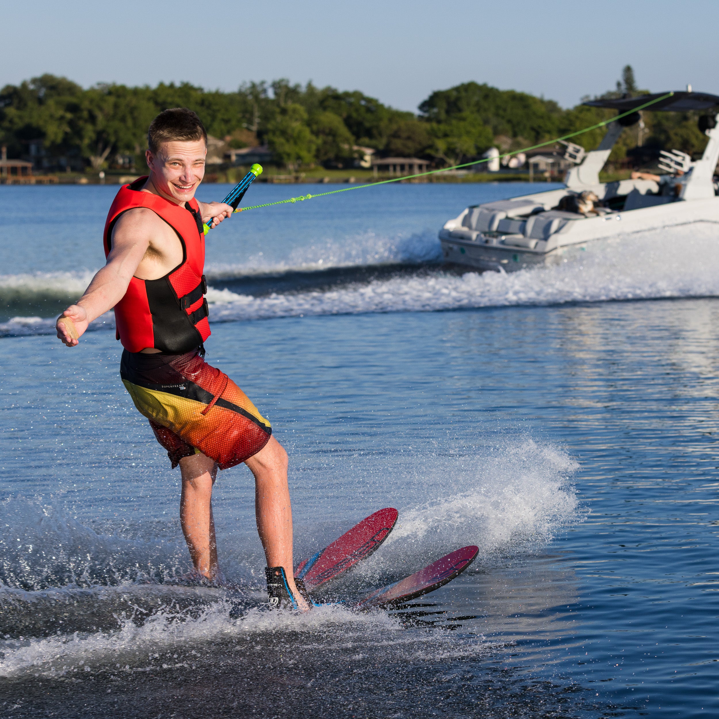Person water skiing on a lake with a boat in the background